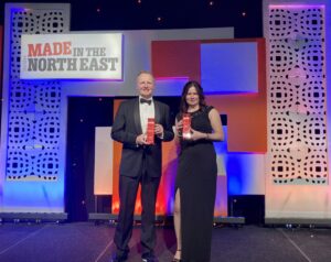 Photo of a man and a woman, both holding an award